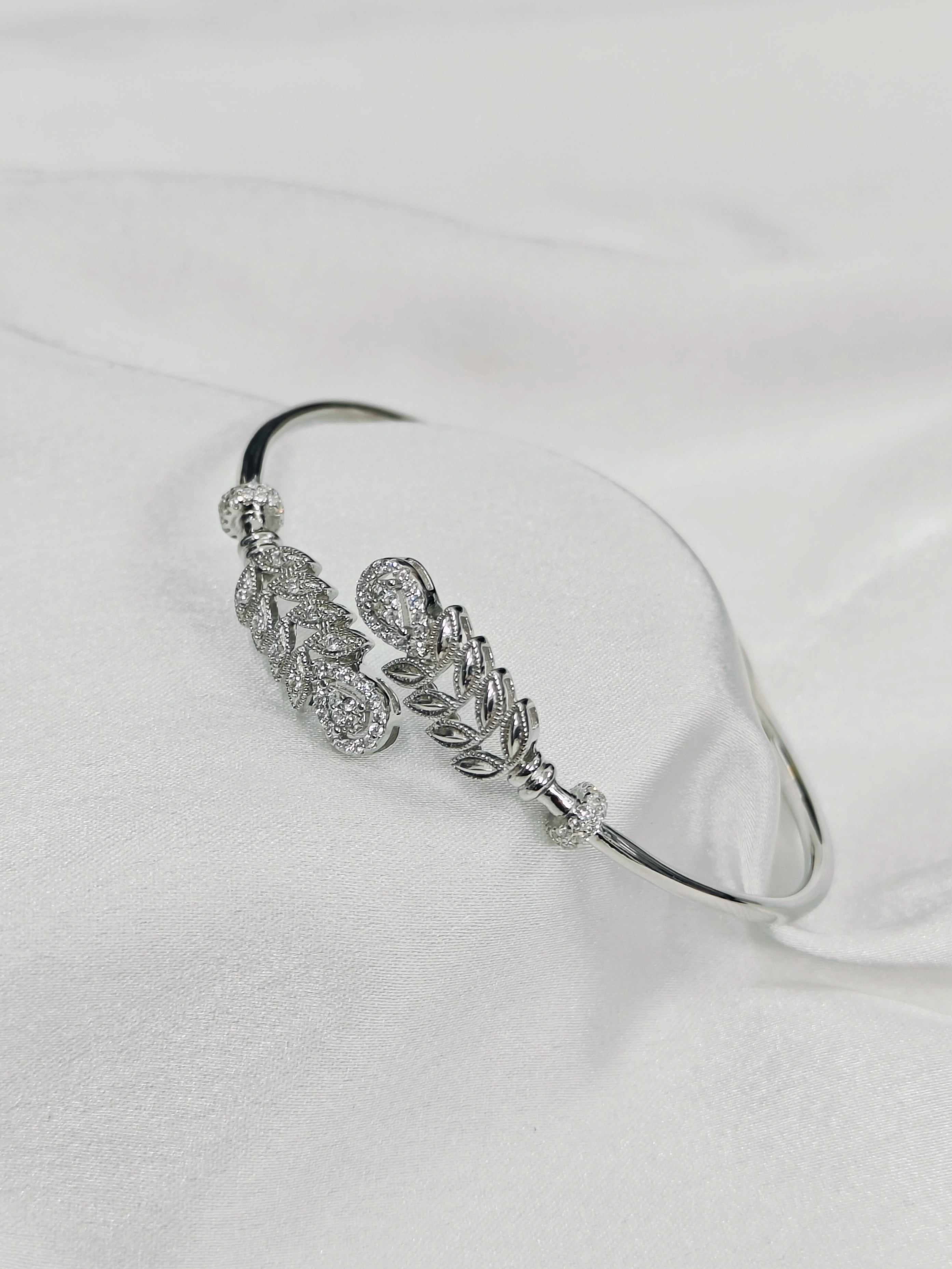 Silver bracelet with floral design on a white background